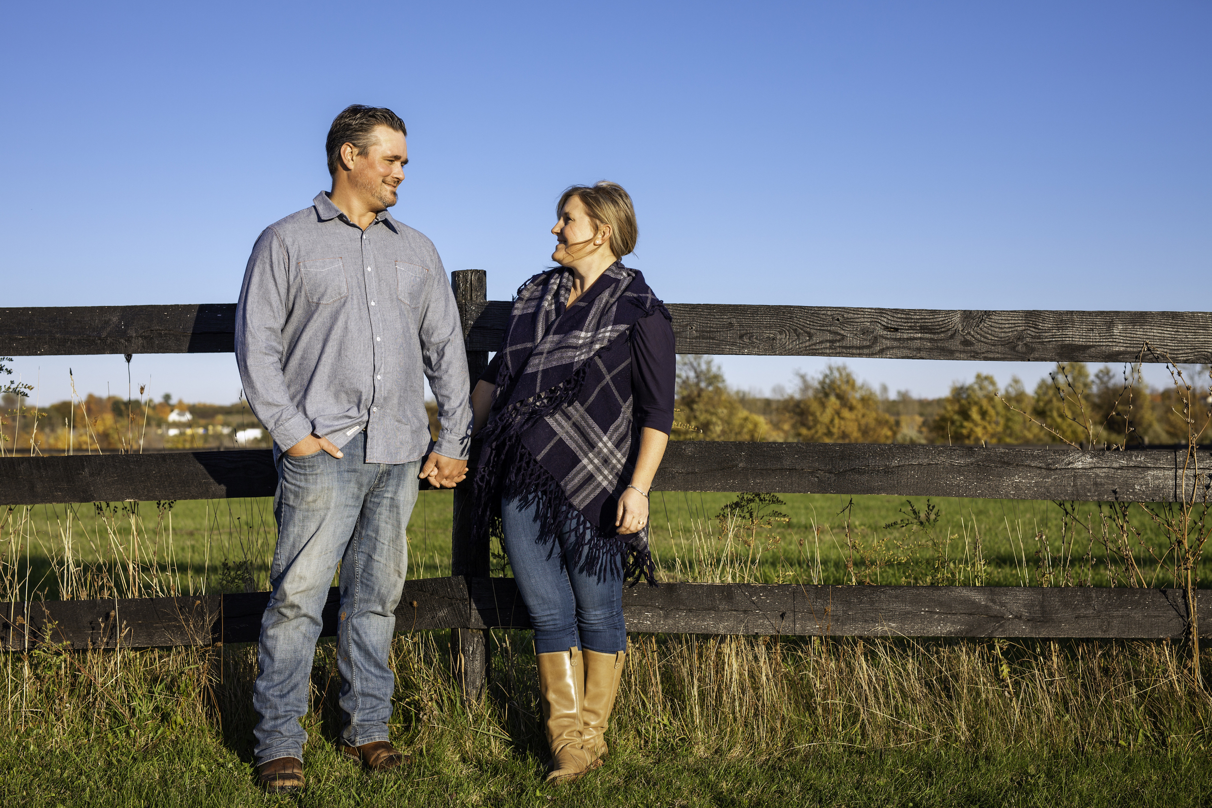 Couple standing by a fence