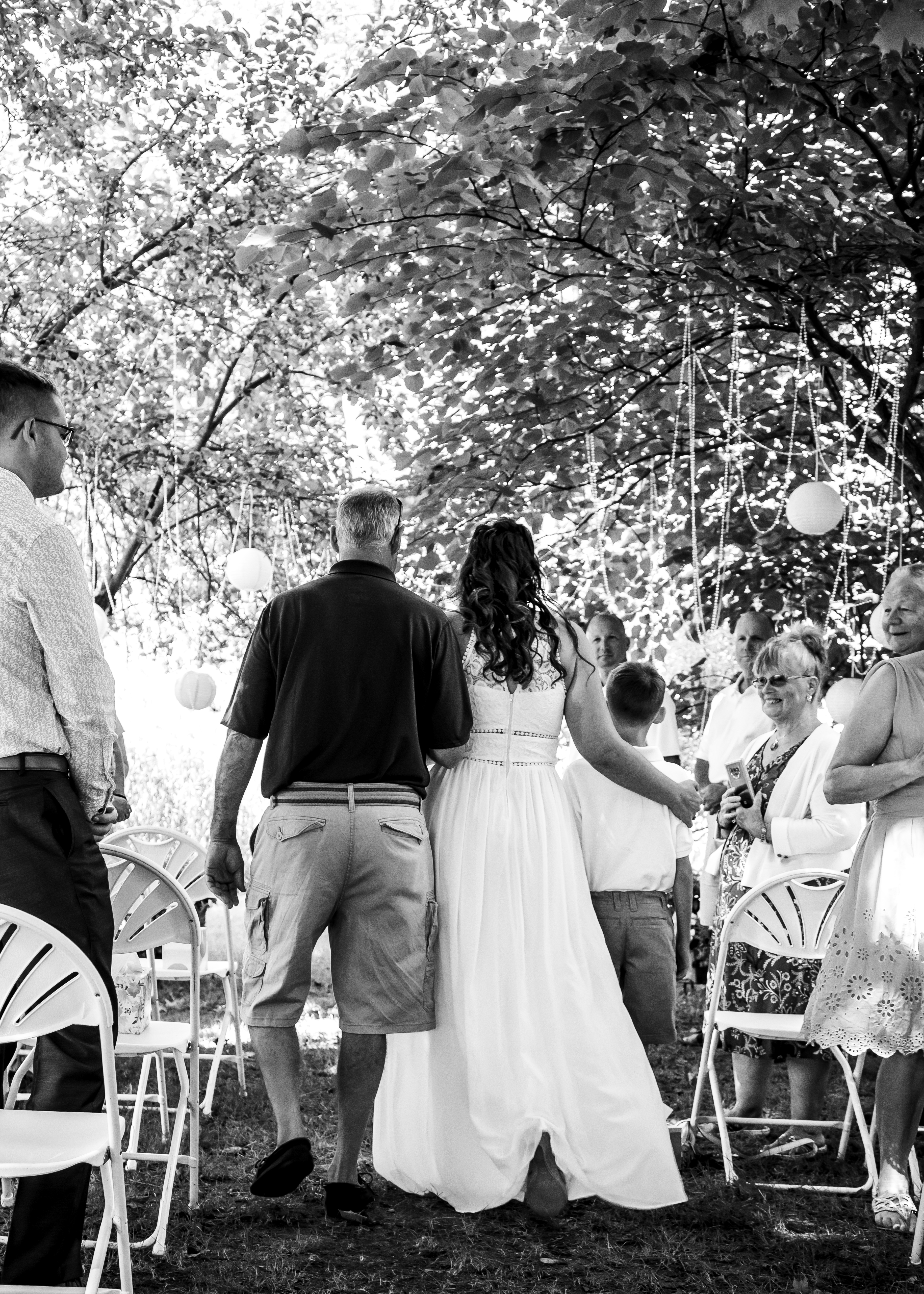 Father and bride from behind walking down the aisle