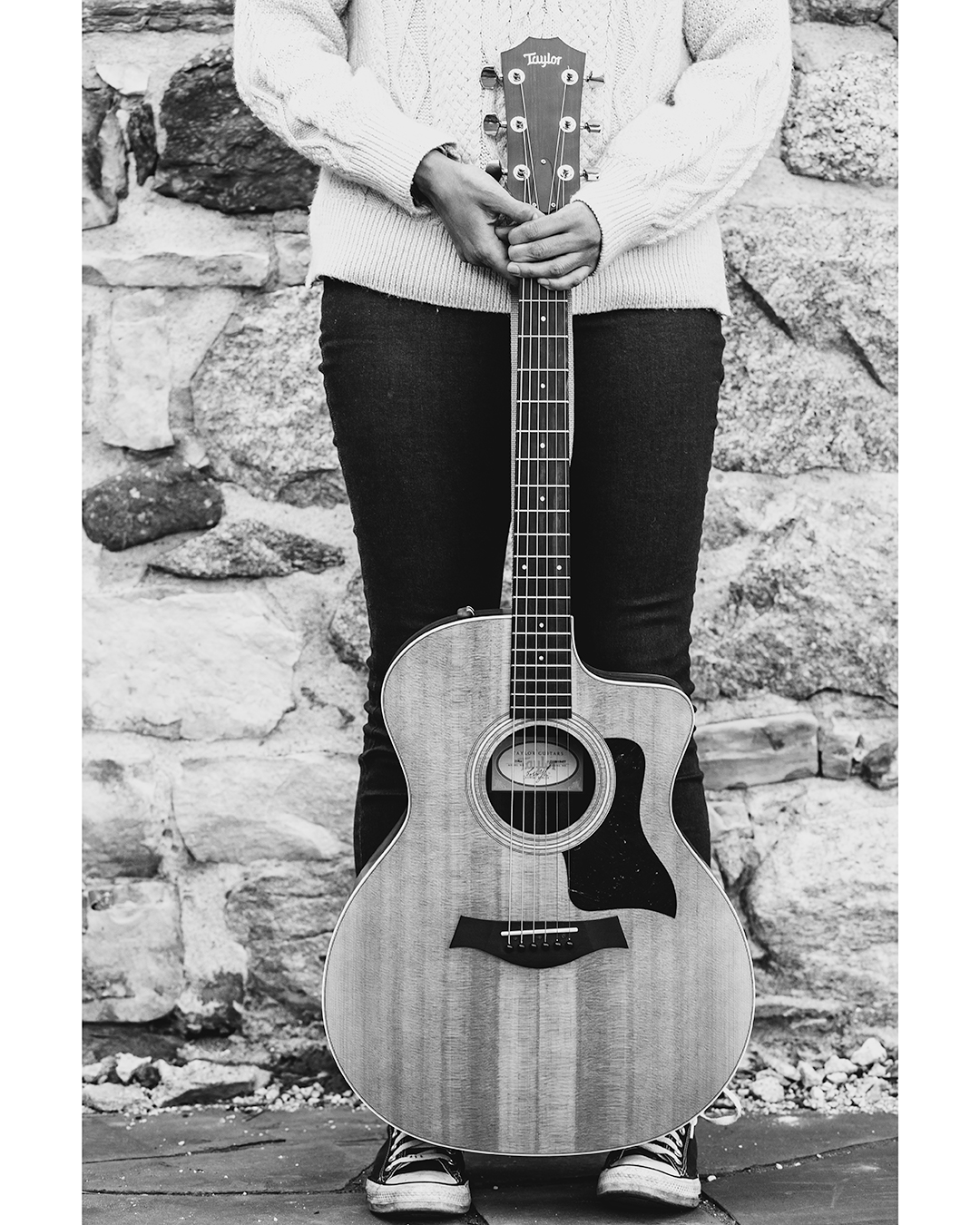 Black and white image of person holding a guitar
