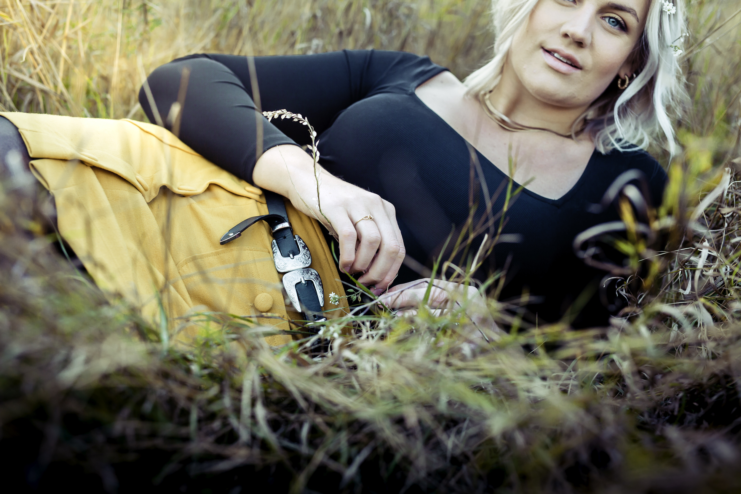 J playing with grass while laying down