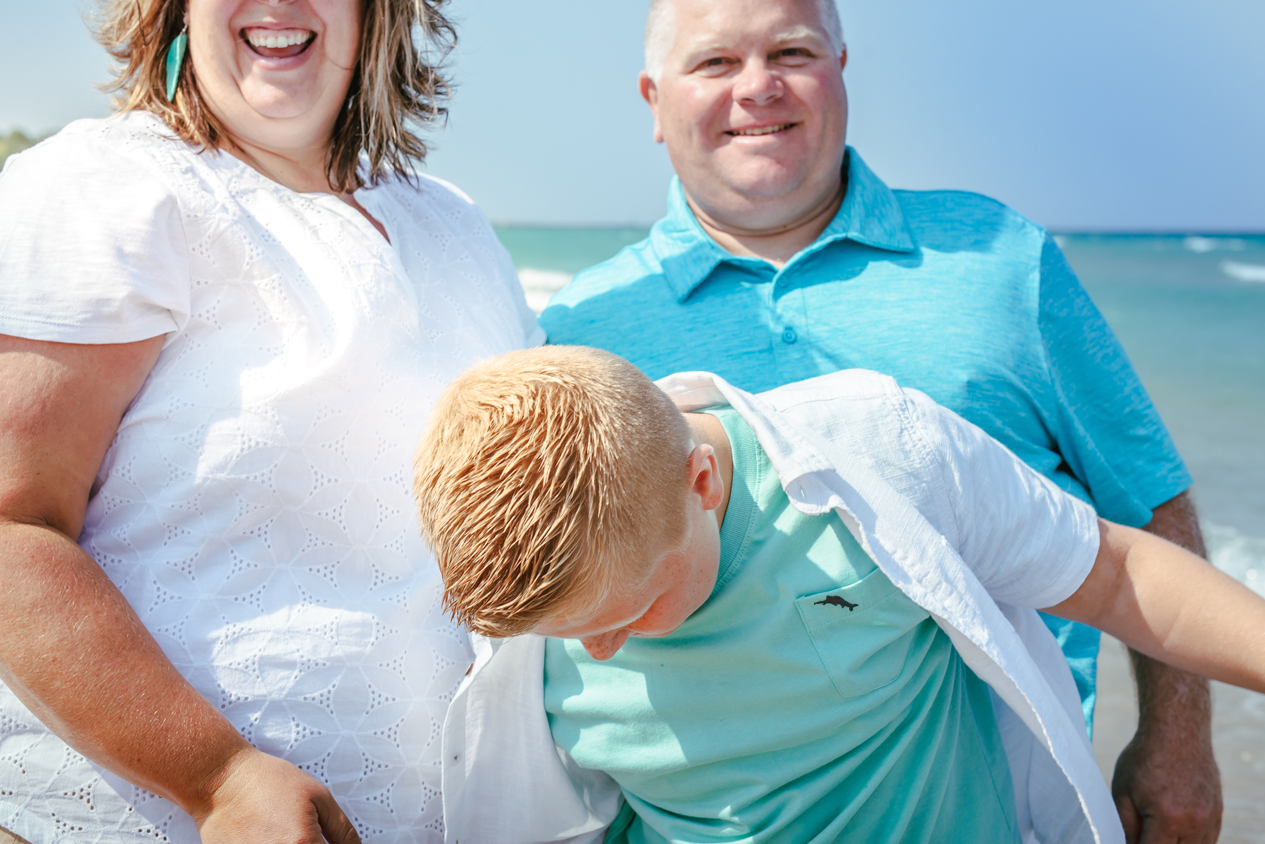 Family smiling by the water