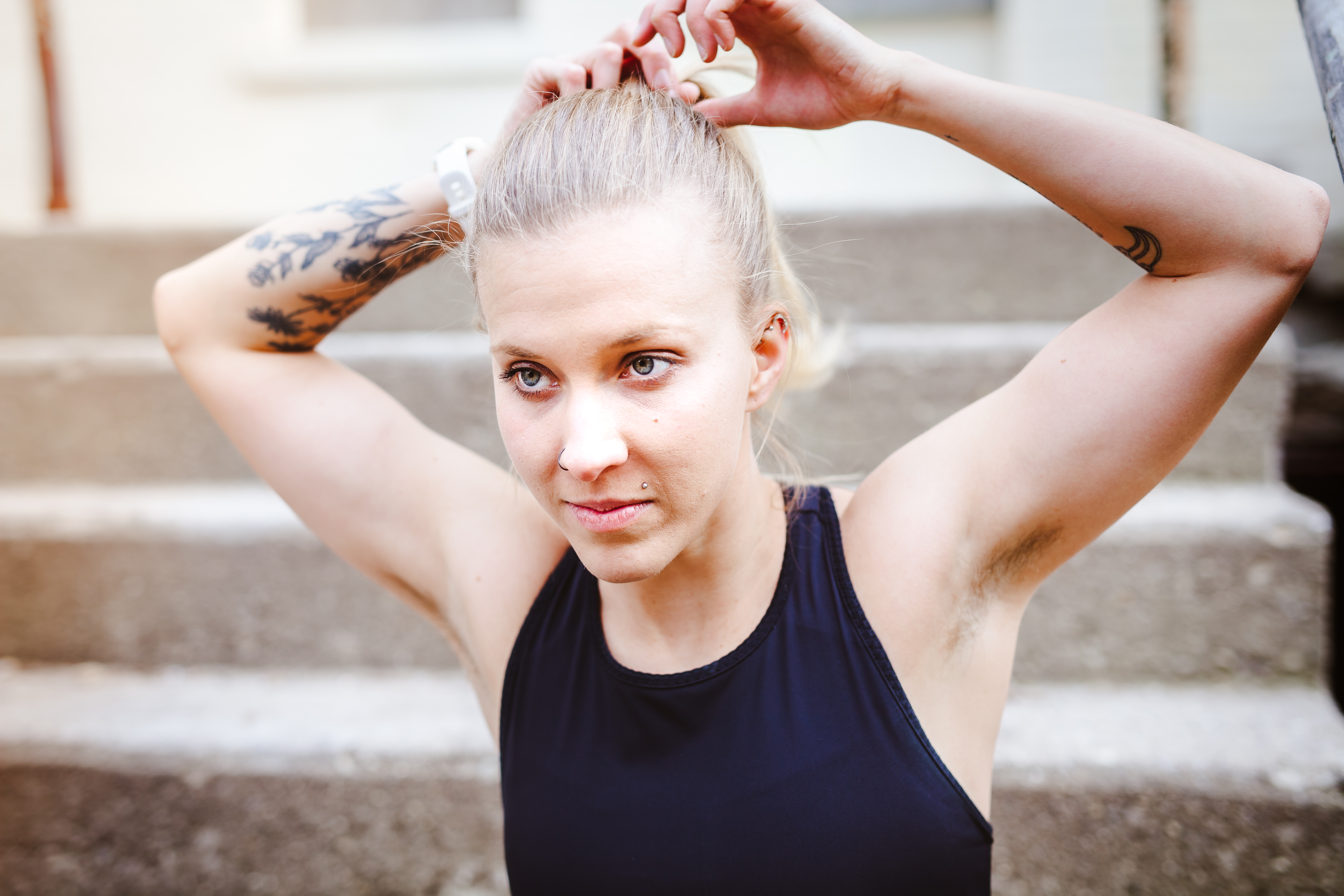 Woman tying back hair in ponytail
