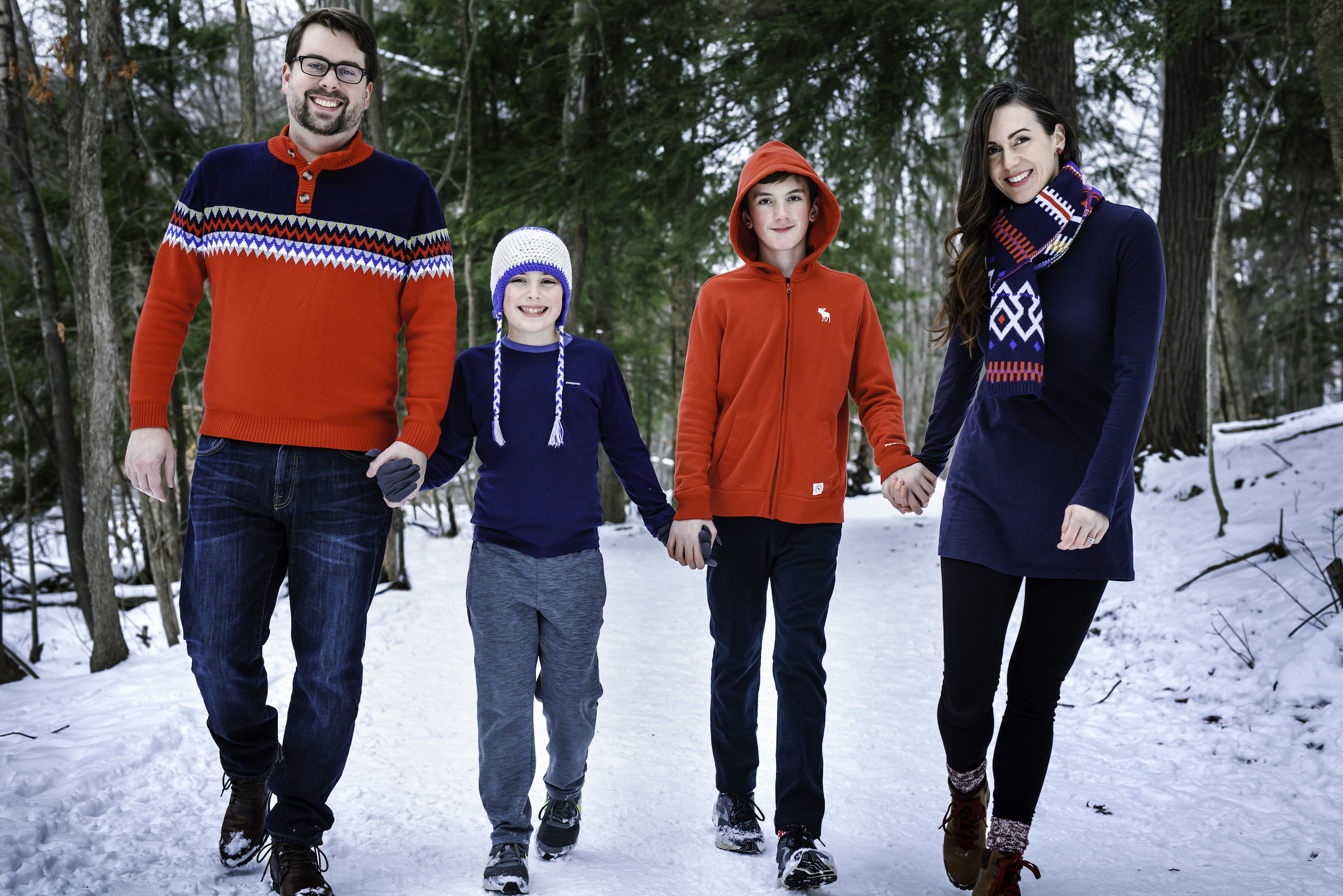 Family holding hands on wooded path