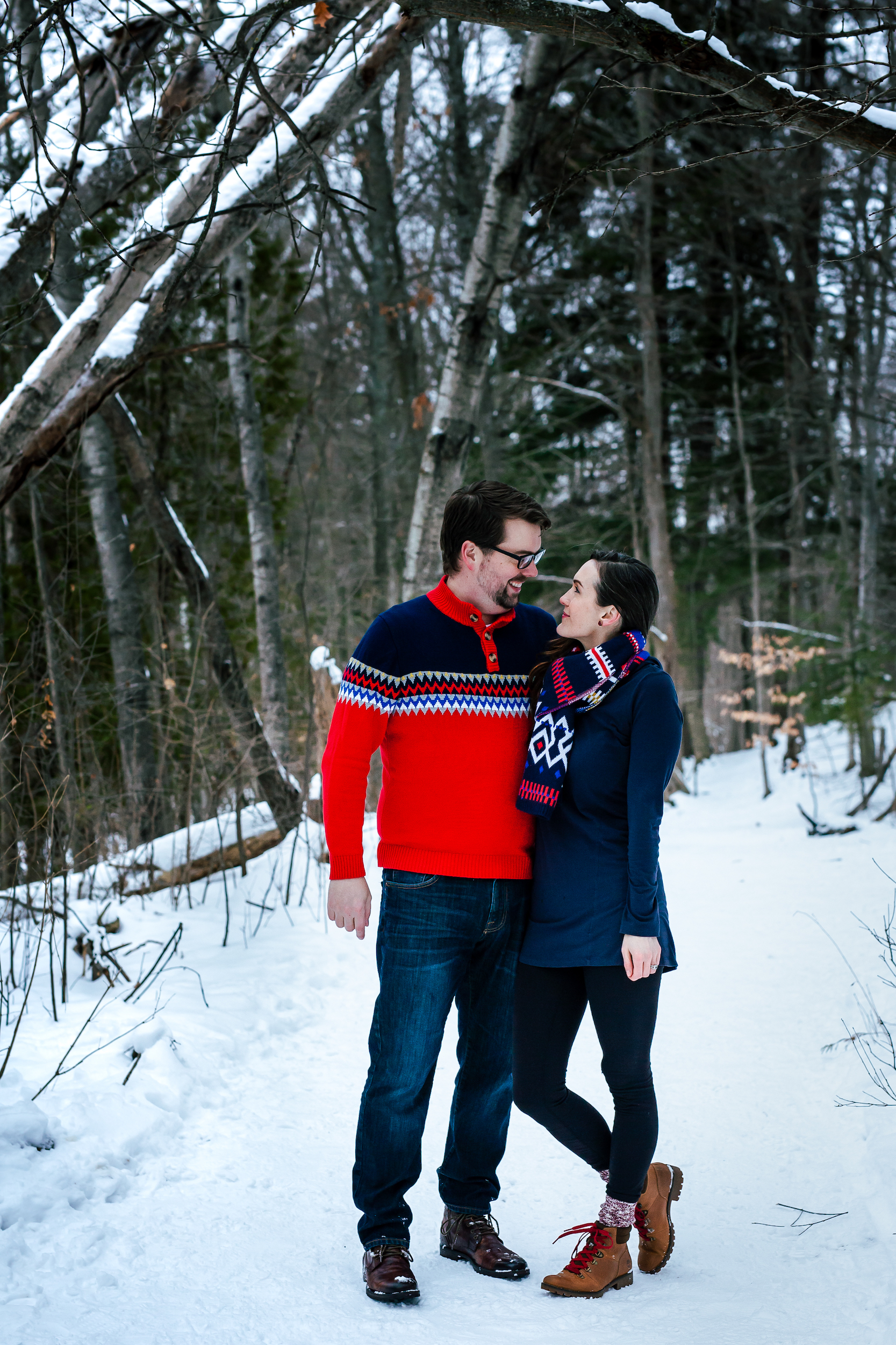 Couple smiling at each other in the woods